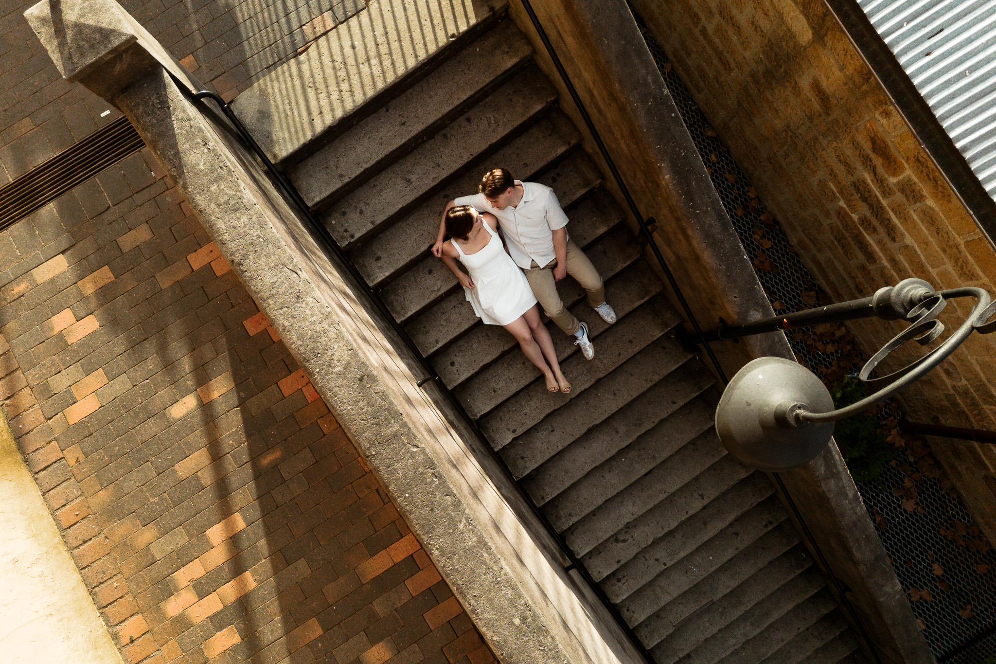 A couple recently engaged sitting at the Argyle Stairs on the Rocks in Sydney